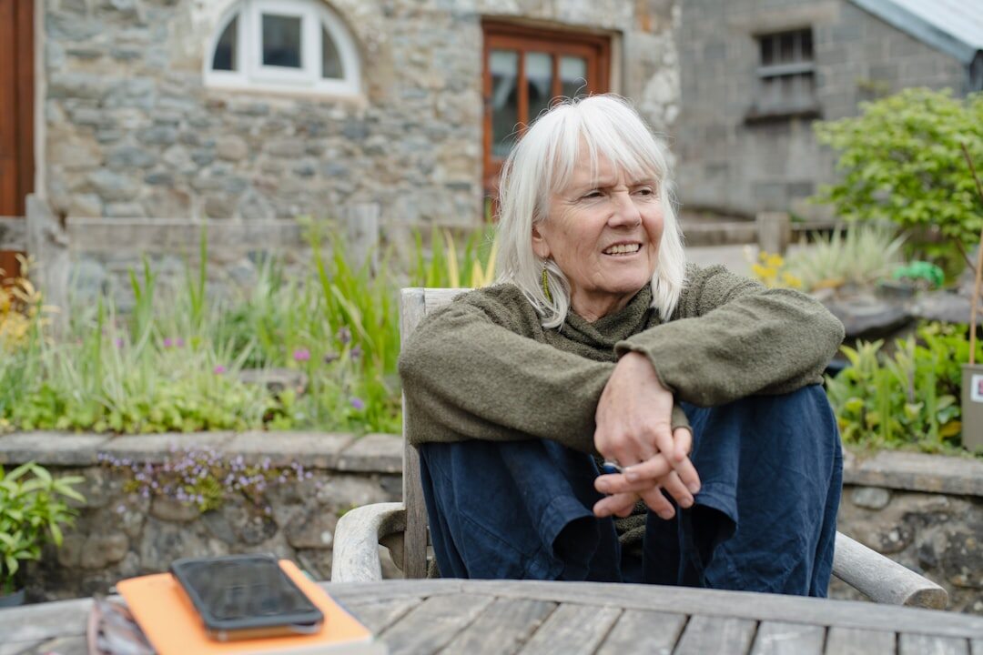 Smiling senior woman holding a membership card outdoors